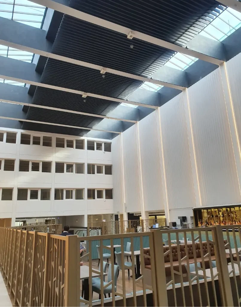 interior of modern building with large open space, high ceiling and tables and chairs