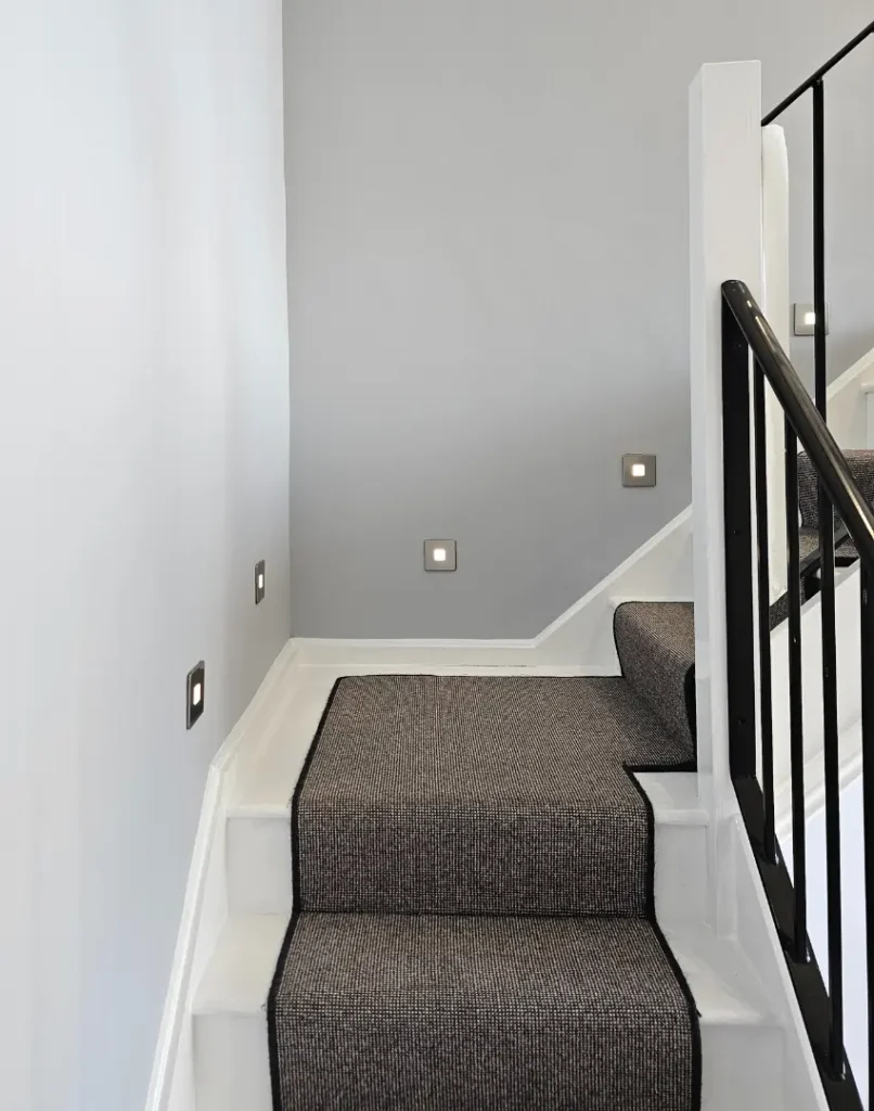 painters and decorators ruislip work - staircase with white woodwork, black metal bannisters and grey carpet