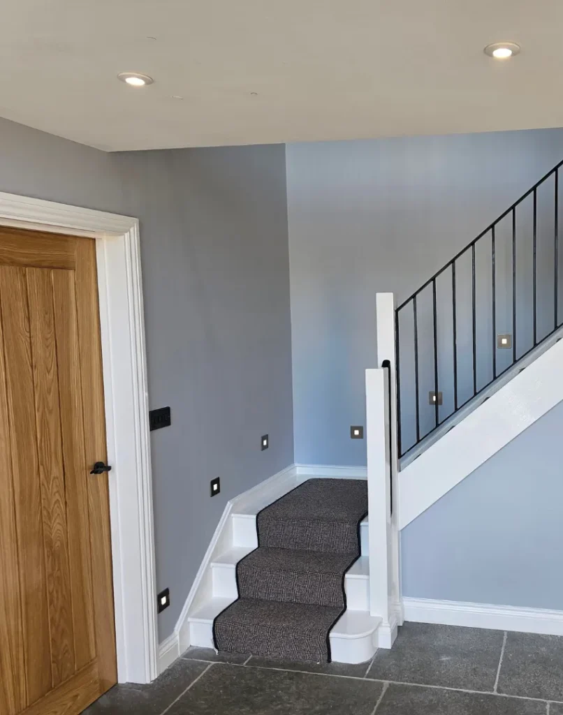 house painter and decorator near me - image shows interior decoraring of stairs and hallway, with grey paint, wooden doors and grey carpet runner